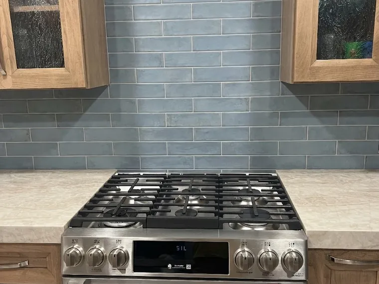 Kitchen renovation idea: dusty blue tile backsplash with honey oak cabinets