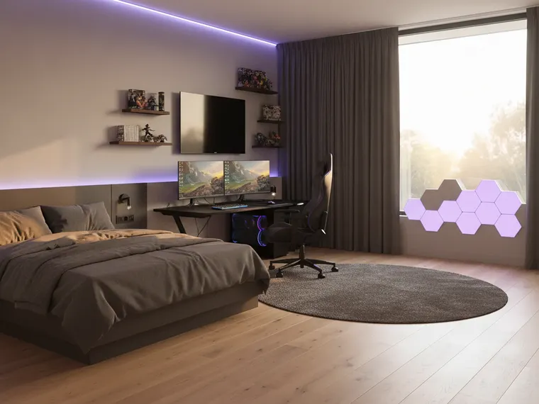 Gamer bedroom idea: low platform bed with dark bedding, a black gaming desk with two monitors by the window, hexagonal LED wall panels and a purple ceiling strip