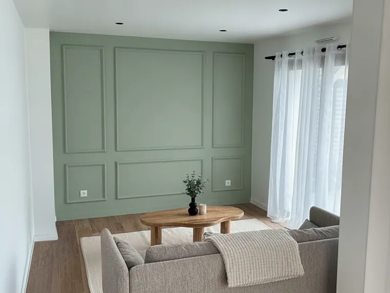 Picture frame moulding wall paneling idea: tall rectangular box moulding painted sage green on a living room wall