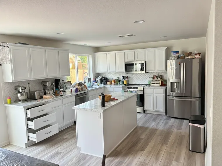 Kitchen corner cabinet idea: base cabinet at the end of the run replaced with three deep white shaker drawers, shown open