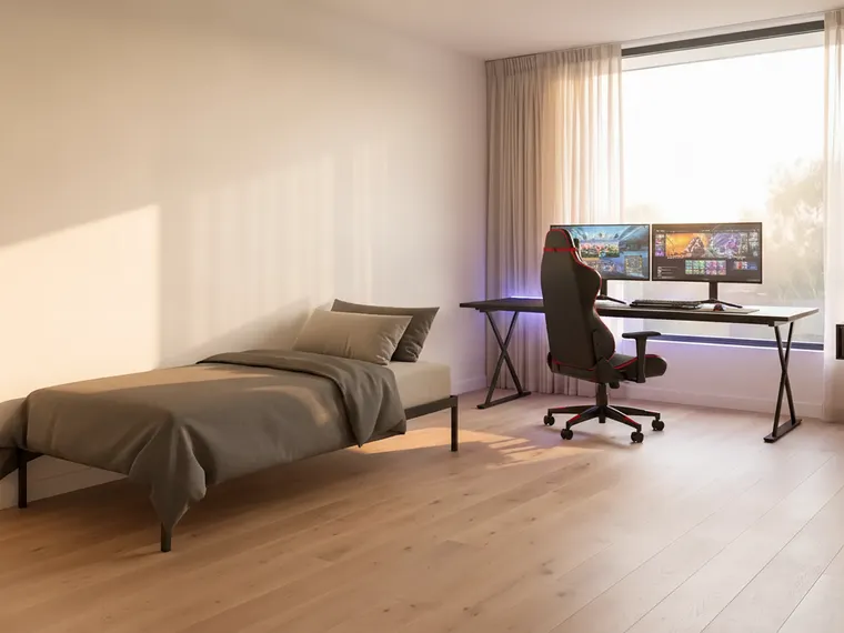Gamer dorm room design: bed with dark grey bedding, black desk under the window with two monitors, gaming chair and LED strip lighting