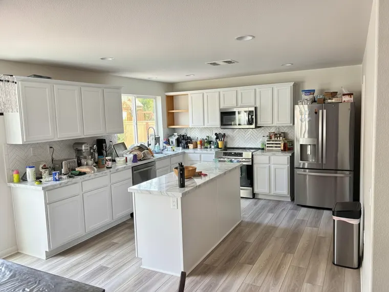 Kitchen corner cabinet idea: upper cabinet beside the window replaced with open oak shelves in a white shaker kitchen