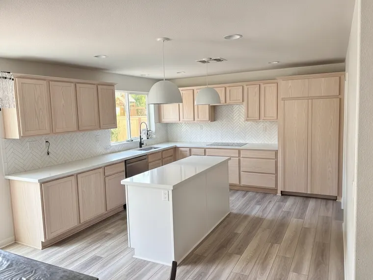 Modern kitchen idea: light white oak slab cabinets with white quartz counters and matte white pendants