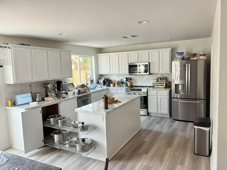 Blind corner cabinet idea: base cabinet open with chrome wire pull-out shelves swung out holding pots and pans