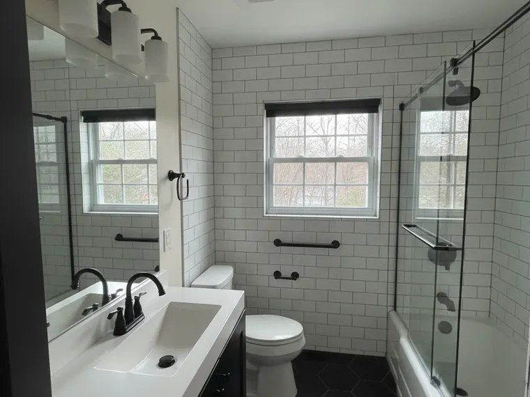 Bathroom renovation idea: white subway tile with dark grout and a black vanity