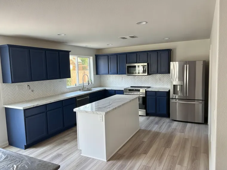 Kitchen renovation idea: deep navy cabinets with white marble countertops and slab backsplash