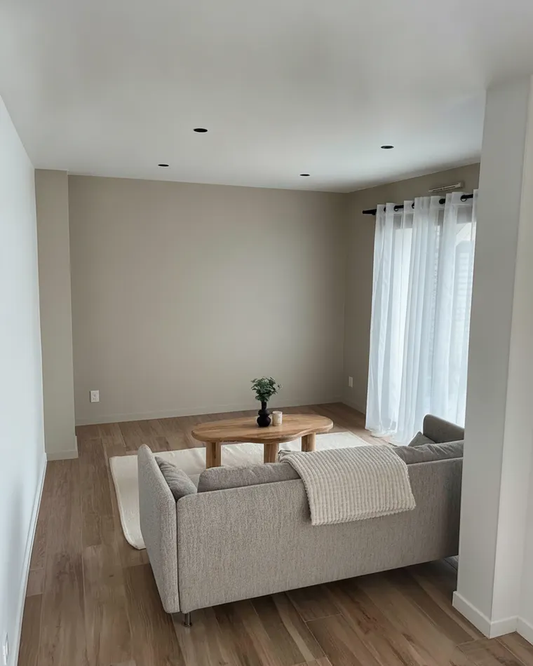 Neutral paint color for living room: warm greige walls with a grey sofa, oak floor and white ceiling
