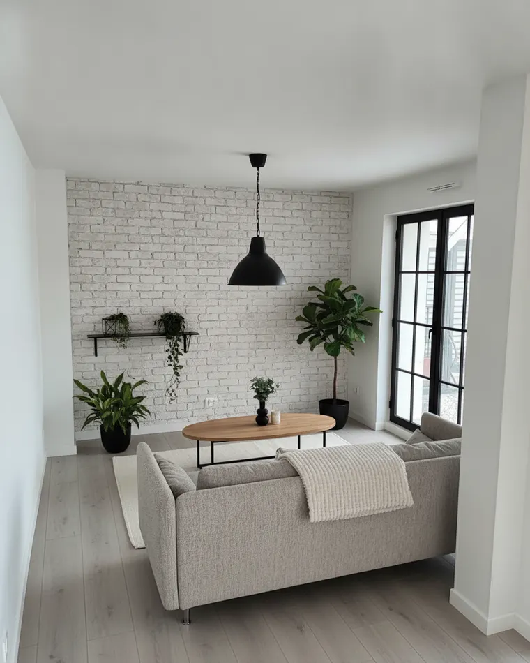 Scandinavian industrial living room idea: white painted brick wall, black steel-framed glass door, black pendant, light grey sofa, oak and steel coffee table, plants