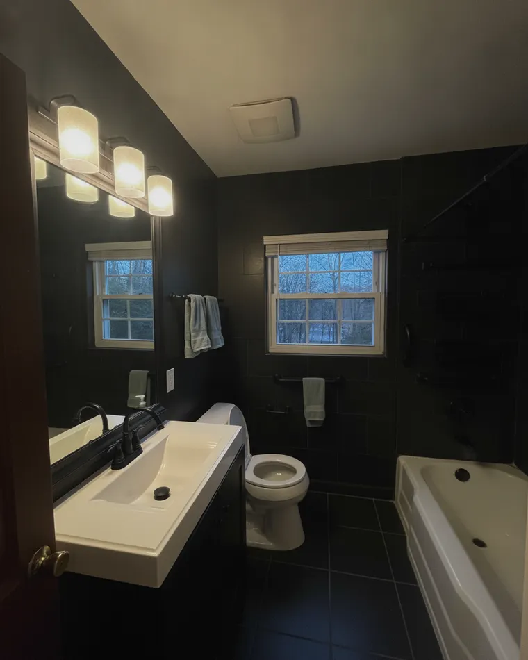 Black bathroom idea: all matte black tile, black vanity with white top and matte black fixtures