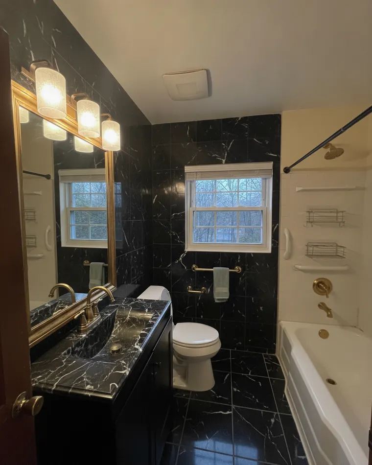 Black marble bathroom idea: black marble tile with white veining, polished brass fixtures