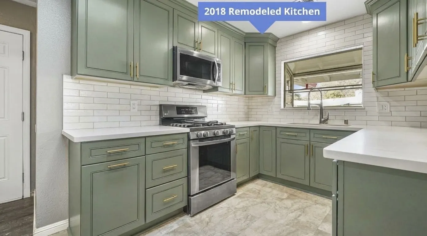 Sage green painted cabinets with brass hardware against existing white subway tile