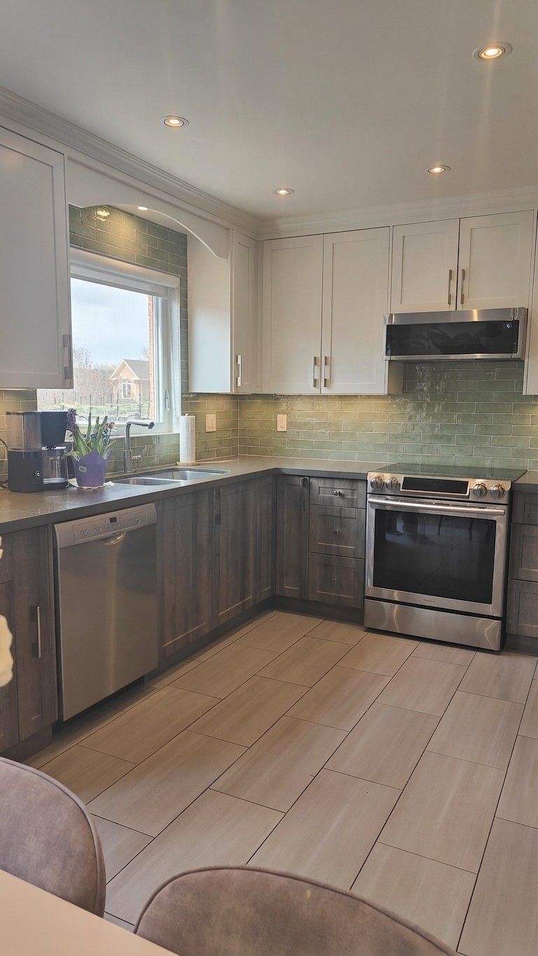 Same kitchen with sage green subway tile backsplash, everything else unchanged