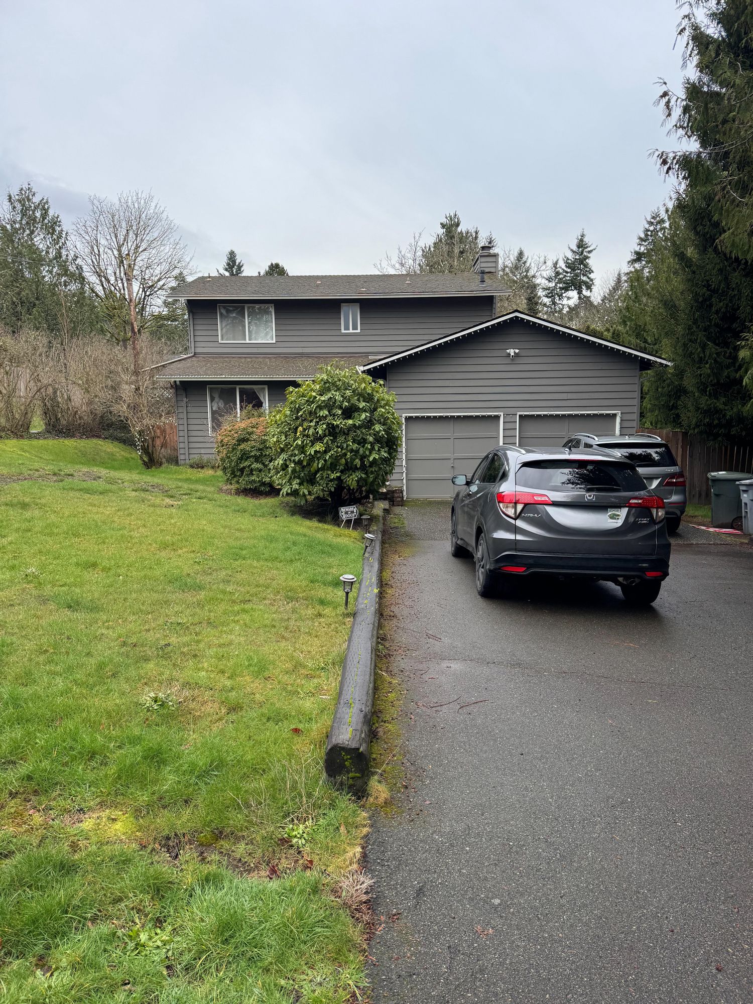Brick house exterior before update — gray split-level with attached garage in PNW