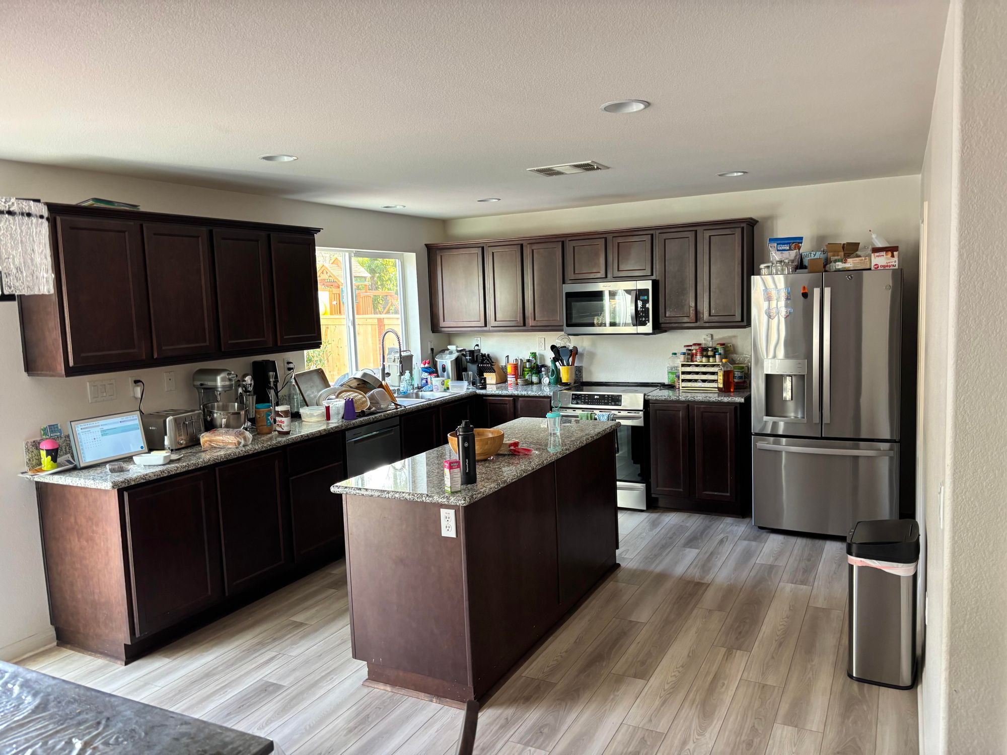 The original kitchen — dark espresso cabinets, brown granite, dim lighting