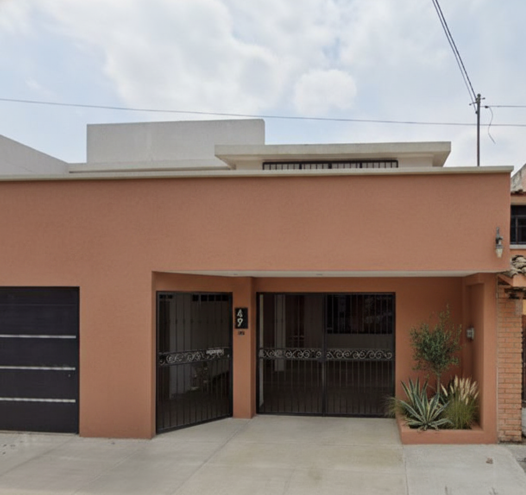 Muted terracotta direction with cream trim and black iron gates