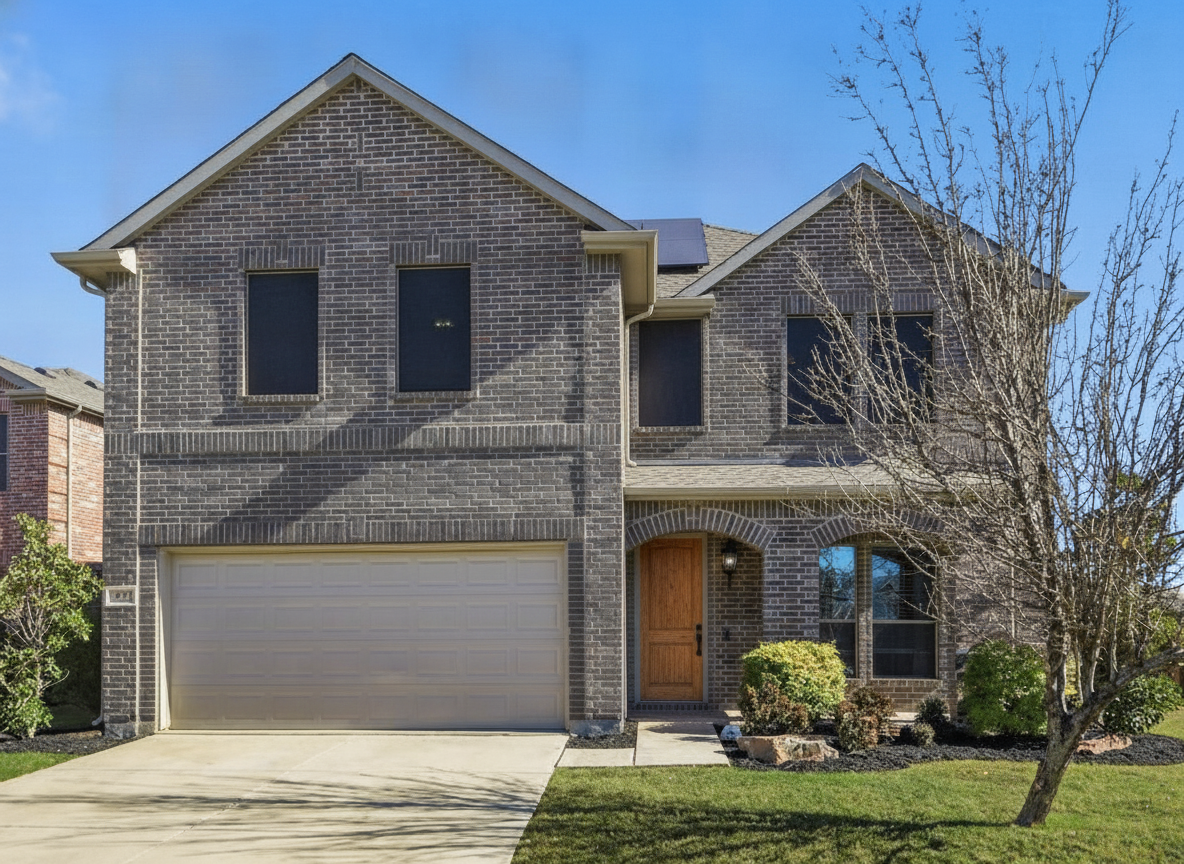 The same brick house in a deep warm gray-brown with white trim and a natural wood front door